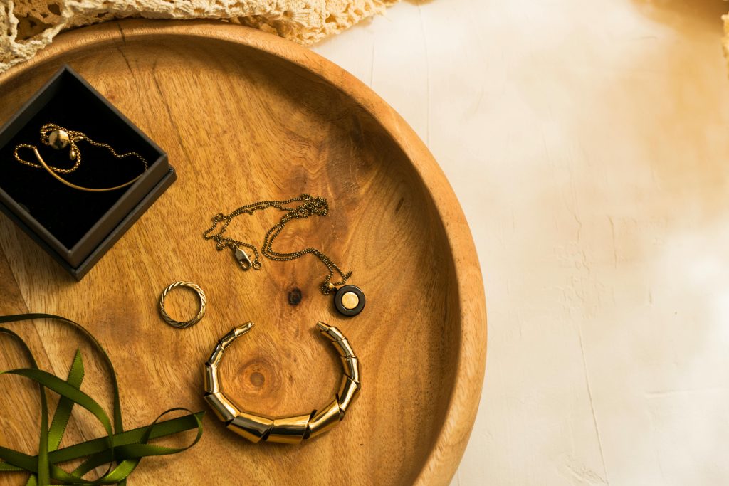 A selection of gold jewelry elegantly arranged on a wooden tray.